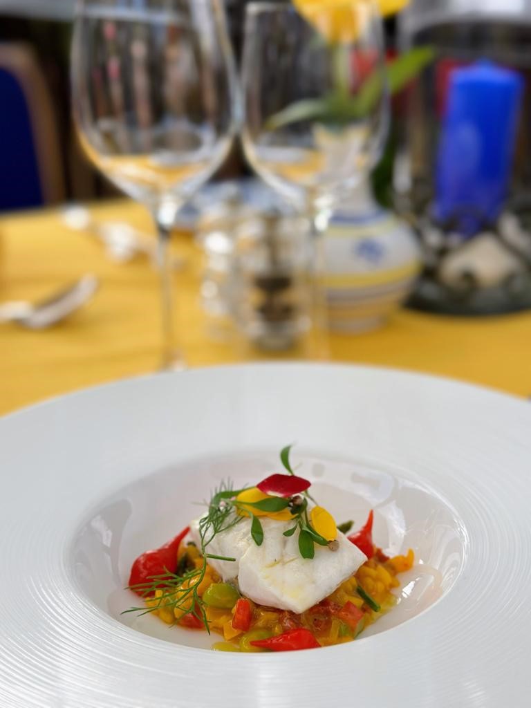 Abschließender Anstrich: Cremiger Reis mit Sobrasada und Wolfsbarsch, dekoriert mit frischen Kräutern und Paprikapulver. Serviert mit einem Hauch Olivenöl und begleitet von einem leicht gekühlten Roséwein oder Sommerwein.